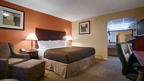 杜兰特Best Western Markita Inn的配有一张床和一把椅子的酒店客房