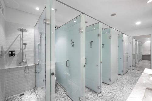 雅加达基尼胶囊旅馆的浴室里一排玻璃淋浴间