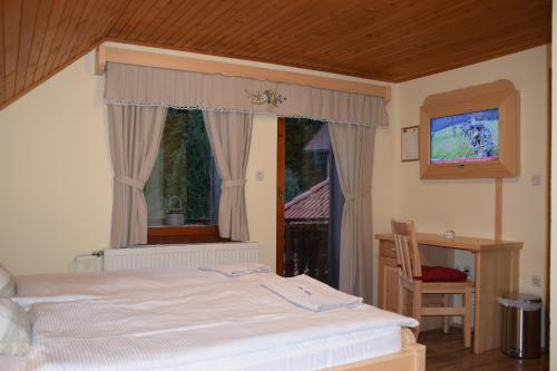 索尔察瓦Farm Stay "Alpine Dreams"的一间卧室配有一张床、一张书桌和一个窗户。