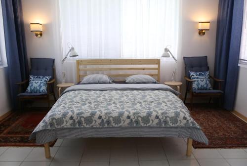 森特什Sára Vendégház的一间卧室配有一张床和两张蓝色椅子