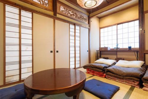 富山边缘旅舍的客房设有桌子、床和窗户。