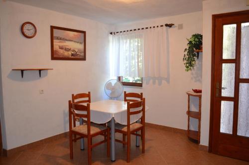 Draga BašćanskaHoliday Home Garina的一间配备有白色桌椅的用餐室