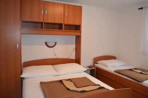 Draga BašćanskaHoliday Home Garina的小房间设有两张床和木制橱柜