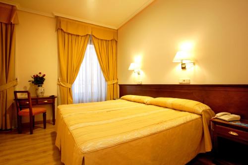 马德里西塞拉诺斯旅馆的一间酒店客房,配有一张床和一部电话