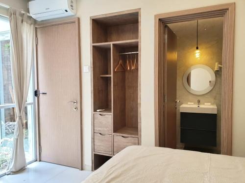 巴淡岛中心Danka@Taman Golf Residence的一间卧室配有床、水槽和镜子