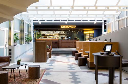 斯德哥尔摩舒适快捷酒店斯德哥尔摩中心酒店的一个带桌椅的餐厅的大堂