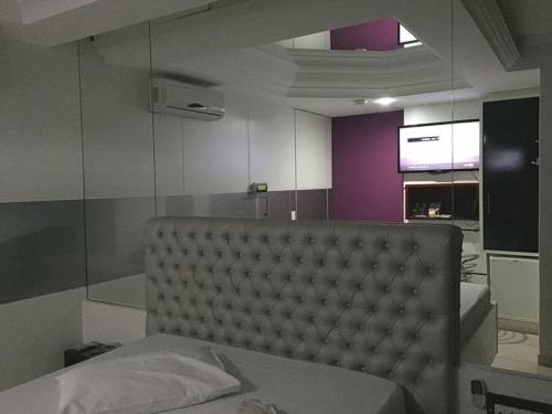 圣若泽Motel 2001 (Adults Only)的一间卧室配有一张带柔软床铺和紫色墙壁