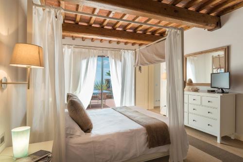 蒙特卡蒂尼泰尔梅Le Panteraie的一间卧室设有一张天蓬床,享有海景