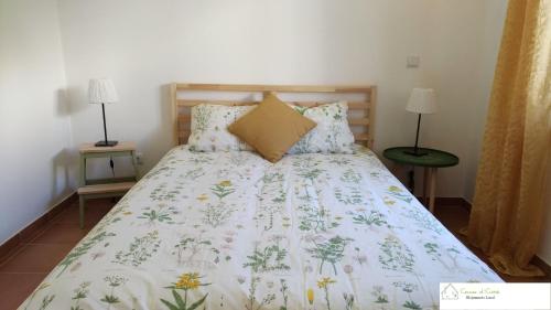 阿尔图拉Casa D'Avó (R/C)的一张带白色棉被和鲜花的床