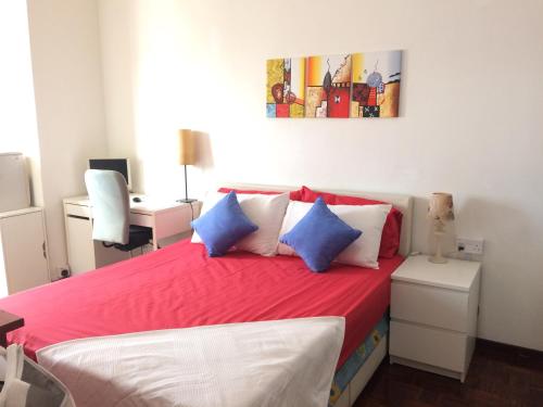 甲洞Suria Kipark Damansara 750sq ft Studio Apartment的一间卧室配有红色的床和蓝色和白色的枕头