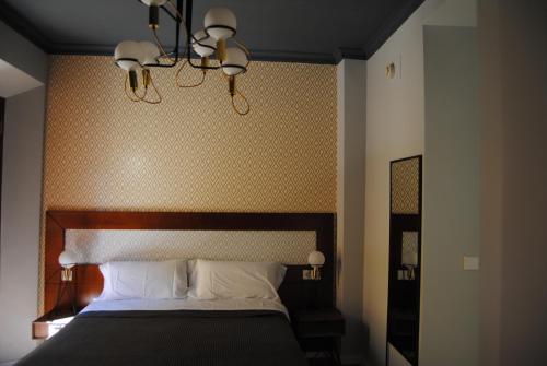 塞维利亚Pensión Córdoba的一间卧室配有一张大床和木制床头板