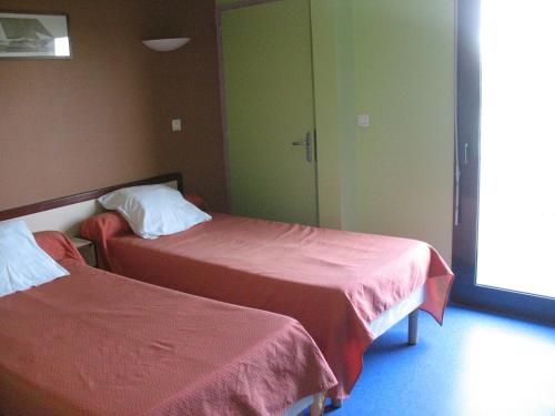 伊泽尔HOME DU BUISSON Hôtel des Familles的酒店客房,配有两张带红色床单的床