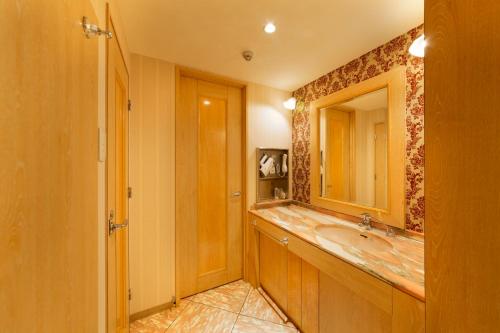 池田露娜酒店池田店（仅限成人）的一间带水槽和镜子的浴室