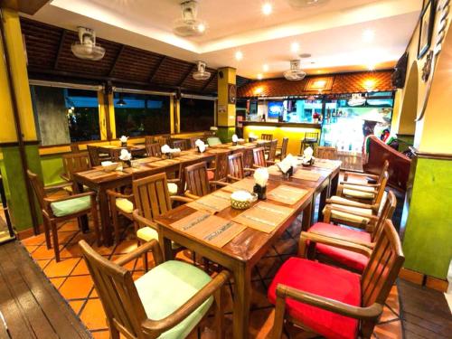 卡塔海滩玛尔之家旅馆的用餐室配有木桌和椅子