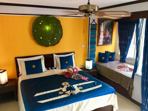 卡塔海滩玛尔之家旅馆的一间卧室设有一张蓝色和黄色的墙壁。
