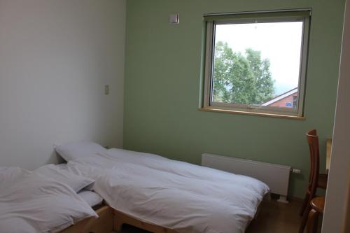 二世古新雪谷纳鲁旅馆的带窗户的客房内设有两张单人床。