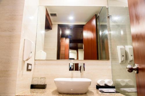 诺伊达阿森商务酒店的一间带水槽和镜子的浴室
