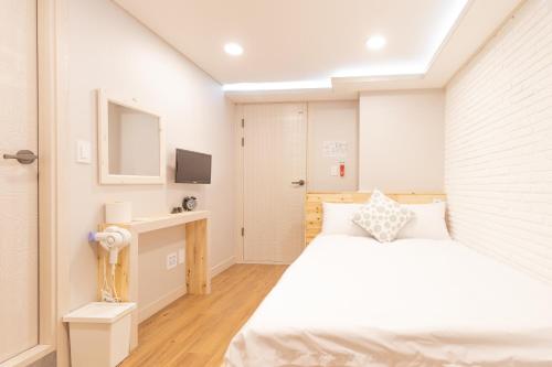 首尔Dawoo House 1 in Hongdae的一间白色卧室,配有床和电视