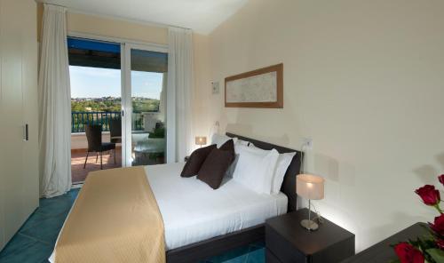 米萨诺阿德里亚蒂科波尔多韦德海滩公寓的一间带白色床的卧室和一个阳台