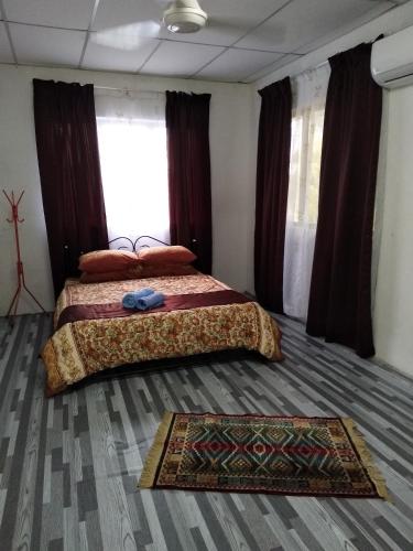 阿罗士打De La Homestay的卧室配有两张床,地板上铺有地毯。