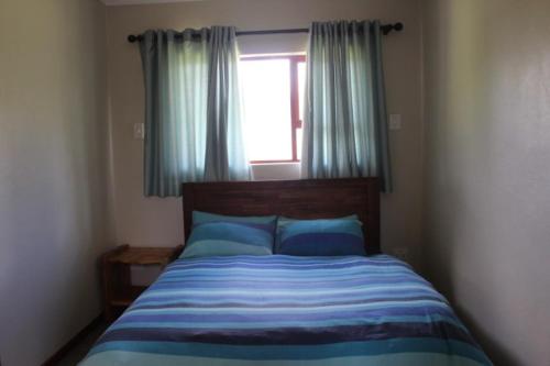 德尔斯特鲁姆Misty Cottage的一间卧室配有床和带蓝色枕头的窗户。
