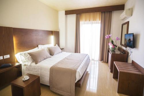 伊斯基亚Casthotels Bristol Terme的一间设有大床和窗户的酒店客房