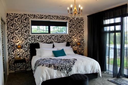 陶朗加Arohanui Rural Retreat B&B的一间卧室配有一张带黑白色图案墙壁的床