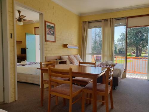 肯普西月亮河汽车旅馆的客厅配有桌子和床。
