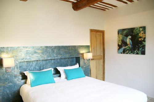 奥佩德Le Clos D'Olea的卧室配有带蓝色枕头的大型白色床