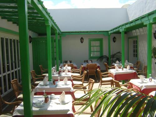 普拉亚布兰卡卡萨德尔额木巴加多酒店的庭院里的餐厅配有白色的桌椅