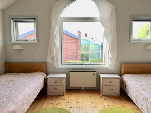奥斯特赫鲁普Feriecenter & Vandland Øster Hurup的带2扇窗户的客房内的2张床