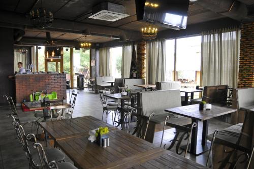 斯维季亚济内斯特之家山林小屋的餐厅设有木桌、椅子和窗户。