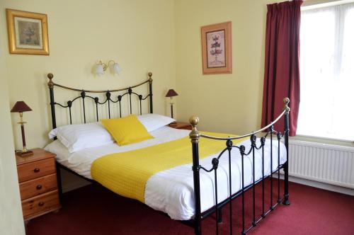 索尔兹伯里维多利亚旅舍的一间卧室配有一张带黄色毯子的大床