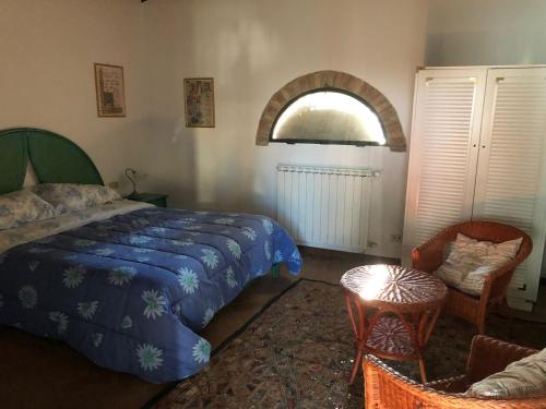 马西亚拉Casa di Romano, La Piazzetta的一间卧室设有一张床、一个窗口和一把椅子