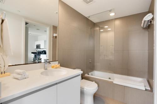 迈阿密海滩迈阿密假期蒙特卡洛公寓的浴室配有盥洗盆、卫生间和浴缸。