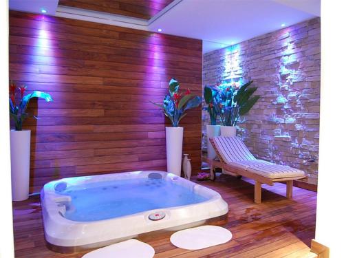 科内利亚诺黎莱斯里贝图雷酒店的一个带长凳的客房内的按摩浴缸