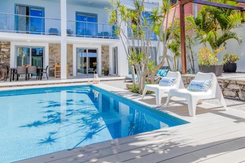 Madalena do MarMadeira Beach House - by LovelyStay的一个带两把白色椅子的游泳池