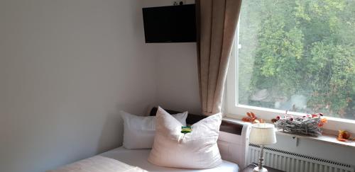 巴特贝特里希Hotel Elfenmühle的客房设有带窗户和枕头的床。