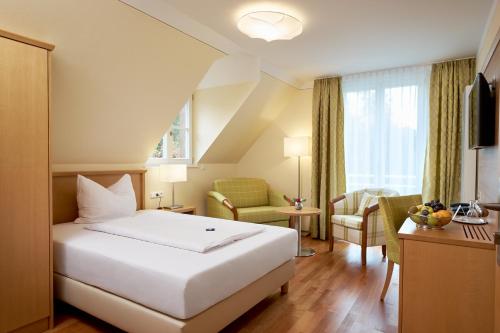 巴特贝林根Flair Hotel Schwanen的酒店客房带一张床、一张桌子和椅子