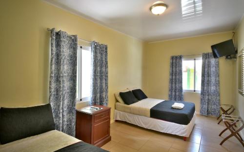 奥拉涅斯塔德Pista Q hostel and apartments的一间卧室配有一张床、一张沙发和窗户。