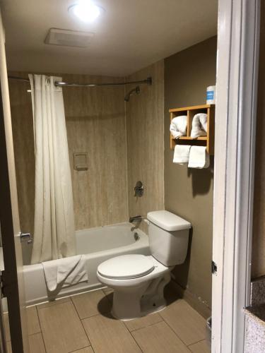埃尔卡洪北门汽车旅馆的浴室配有卫生间、淋浴和浴缸。