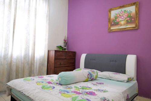 芙蓉Homestay Jasmin Indah, Senawang (free wifi)的一间卧室设有紫色的墙壁和一张带枕头的床