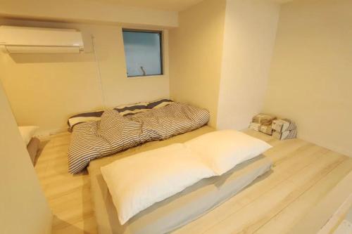 东京Shibuya Anon #A102的一间小卧室,卧室内配有一张床铺