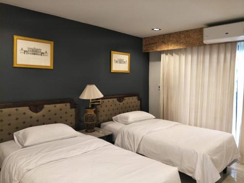 曼谷The 92 Residence的一间卧室设有两张床和一扇带灯的窗户