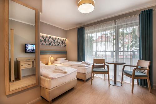 斯维诺乌伊希切瑟萨斯卡敖迪酒店的酒店客房设有两张床和一张桌子。