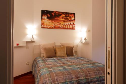 博洛尼亚Bologna Central Apartment的一间小卧室,配有一张带两盏灯的床