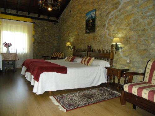 桑提亚纳德玛埃然旅馆的一间卧室设有一张床和石墙