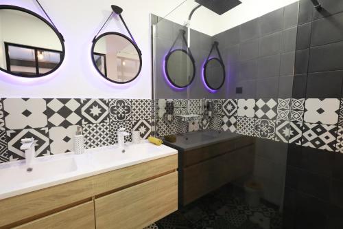Les MichelsCasaCosy的浴室铺有黑白瓷砖,配有水槽和镜子