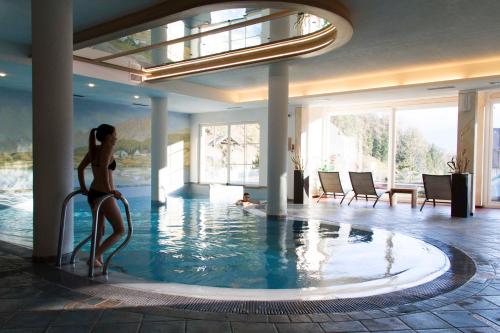 泰塞罗米拉蒙蒂伯格酒店的站在游泳池里的比基尼的女人