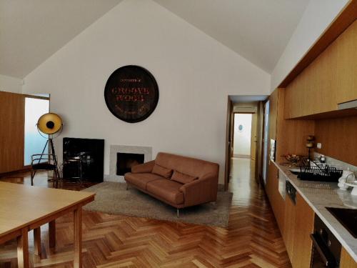 加亚新城Groove-Wood Loft的客厅设有厨房,配有棕色沙发